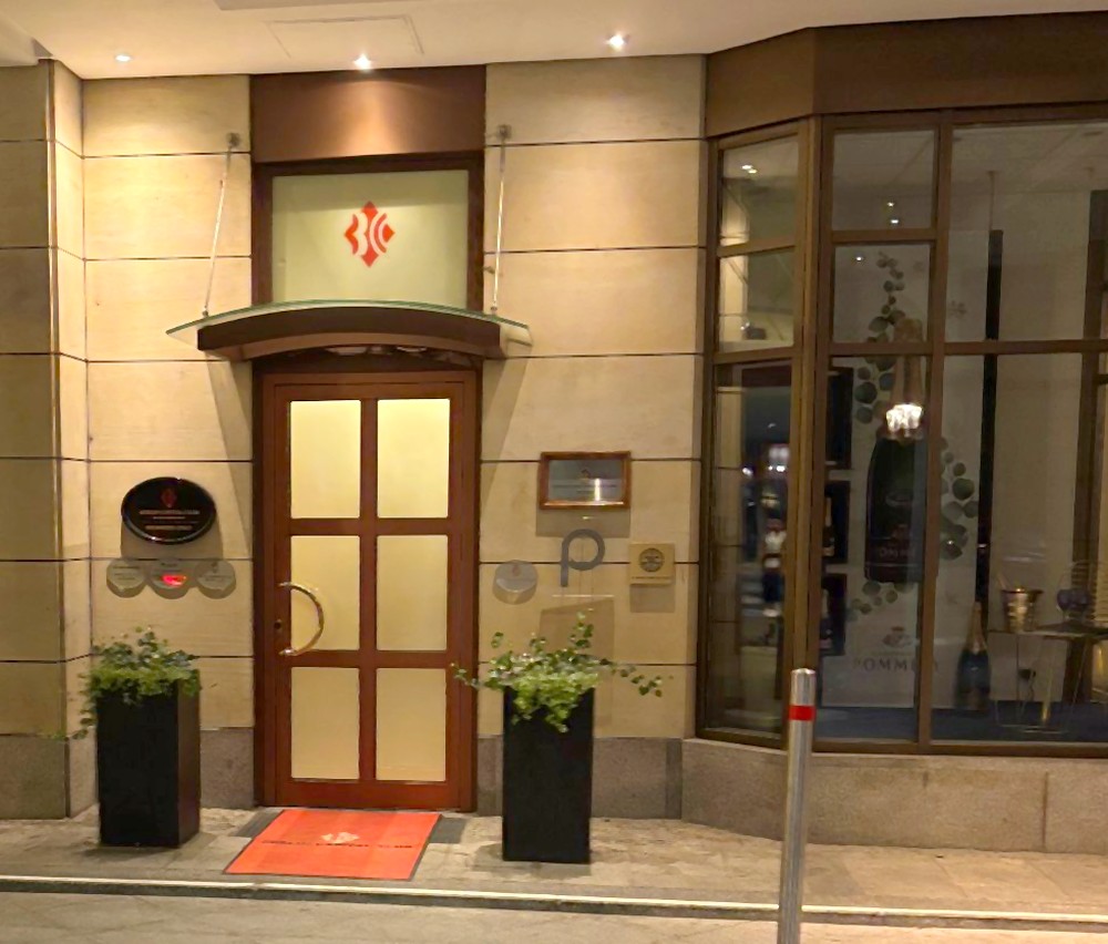 Eingang des Berlin Capital Club in der Anton-Wilhelm-Amo-Straße, abends beleuchtet.